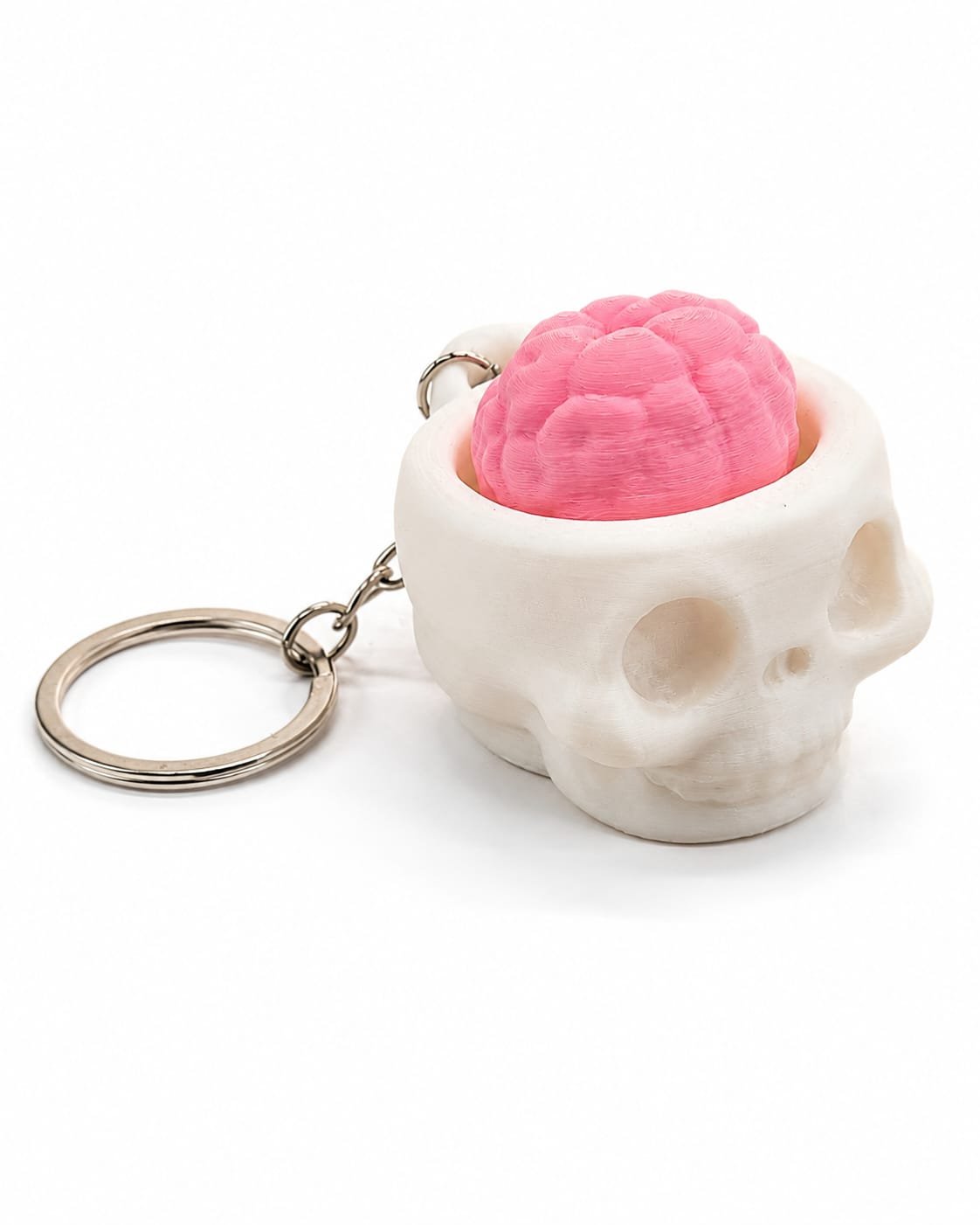Chaveiro de caveira Piclick branco com cérebro rosa clicável visto de lado, com argola de chaveiro
